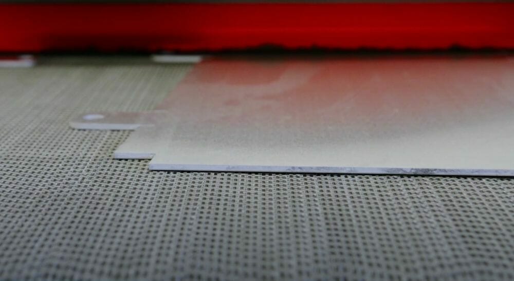 Screenshot from the video showing a part going through sheet metal deburring in the Time Saver.